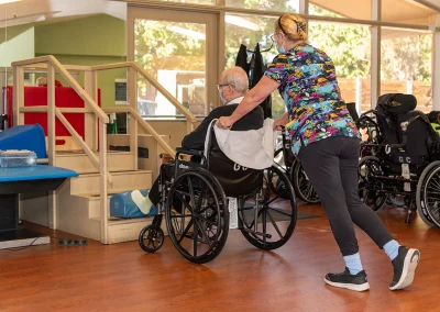 A rehab therapist with a resident in a wheelchair in the rehab gym at Grant Cuesta Sub-acute and Rehab